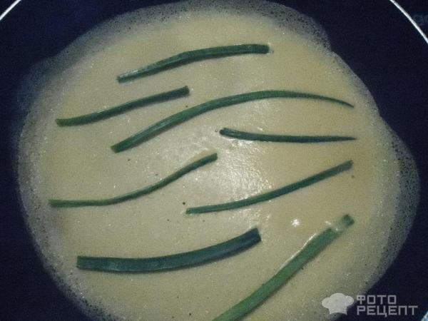 На сковородку наливаем тесто и выкладываем зеленые перья.