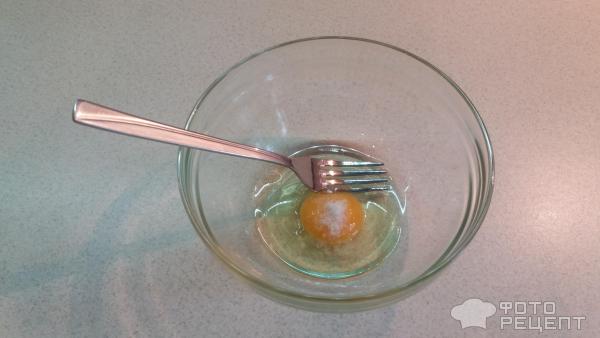 Разбиваем сырое яйцо в мисочку, добавляем щепотку соли и взбиваем вилочкой до лёгкой пены.