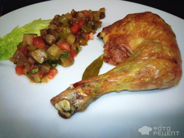 Печёный куриный окорочок и овощная икра на большой белой тарелке